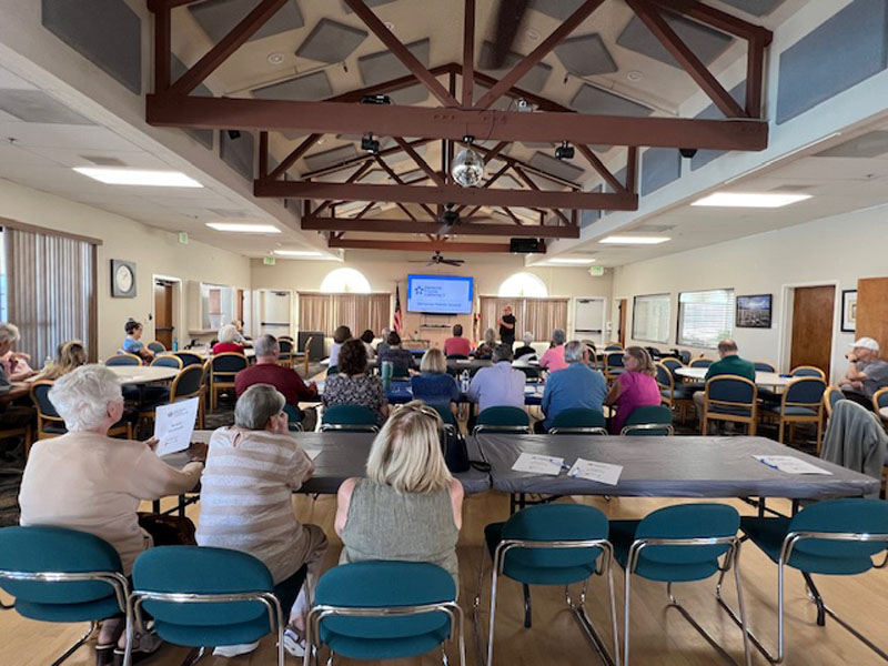 members gather in the ballroom for a speaker presentation